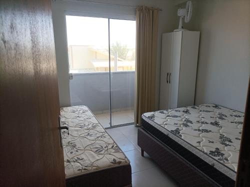 LaranjalAP Beira mar的一间卧室设有一张床和一个滑动玻璃门