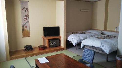 野沢野沢御宿的客房设有两张床、一台电视和一张桌子。