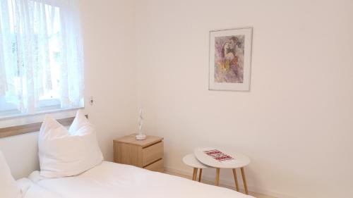 卡尔明茨Ferienwohnung Mioritza的白色卧室配有床和桌子