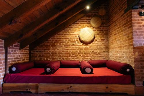 巴克塔普尔Manju Baha Hotel & Restaurant的砖墙房间里一张红色的沙发