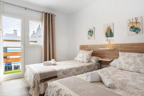 科尼尔-德拉弗龙特拉Apartamento Suite Arco Solo Parejas的一间卧室设有两张床和窗户。