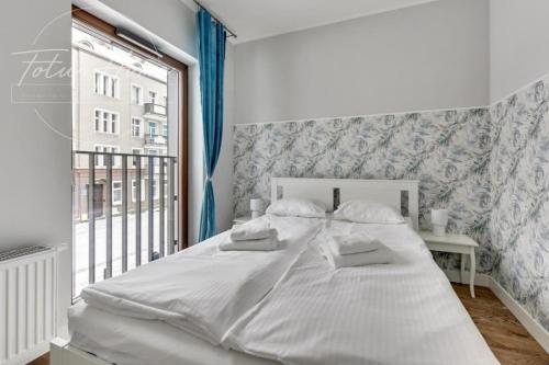 格但斯克TOTU HOME Old Town Gdańsk Marina Apartment的窗户客房内的一张白色床