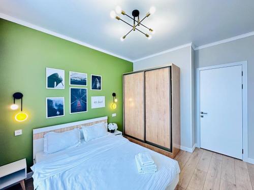 阿斯塔纳Grand Turan Business 2-Room Apartament's的一间卧室设有一张大床和绿色的墙壁