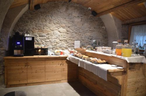 蓬泰迪莱尼奥Le Suites de San Campel RTA的厨房配有餐桌和食物