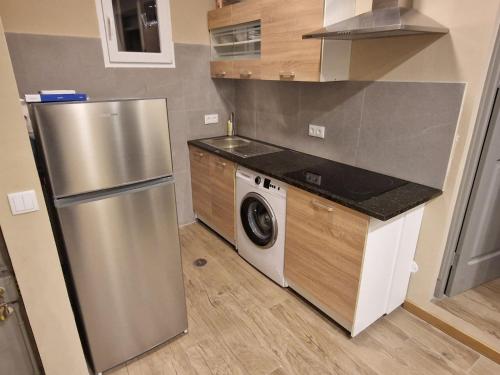 明德卢Apartamento Centro do Mindelo 6 min da praia的厨房配有不锈钢冰箱和洗衣机。