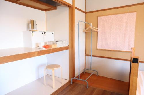 伊势市Ise Guest House Sora的一间设有桌子、凳子和窗户的房间