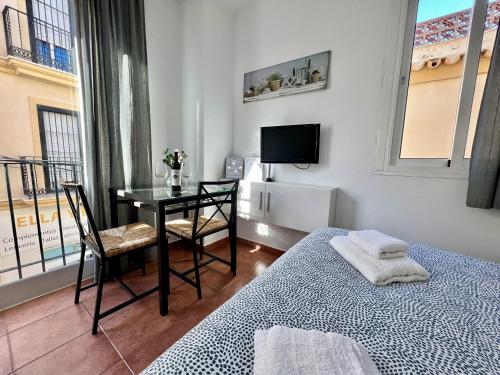 多列毛利诺斯RC La Carihuela by Beehive Vacances的一间卧室配有一张床、一张书桌和一台电视