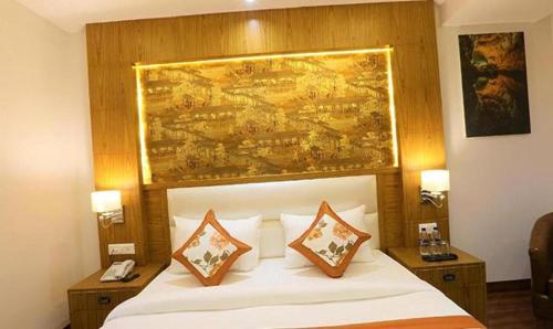 新德里FabHotel Prime Star 17的一张位于酒店客房的床铺,上面有绘画作品