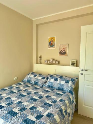 圣乔瓦尼·罗通多Casa Luciana Apartment的卧室配有蓝色和白色的格子床