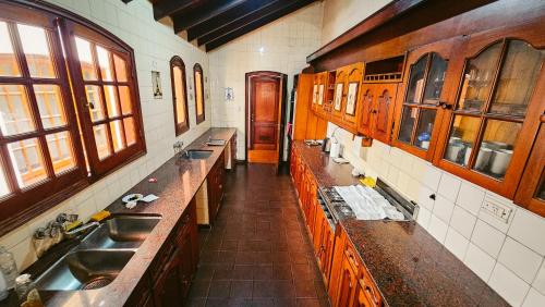 萨尔塔Valhalla Hostel & Suites的一个带两个水槽和木柜的厨房