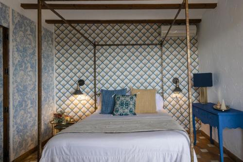 弗里希利亚纳Posada Morisca Charming Hotel Boutique的一间卧室配有一张带木制床头板的床