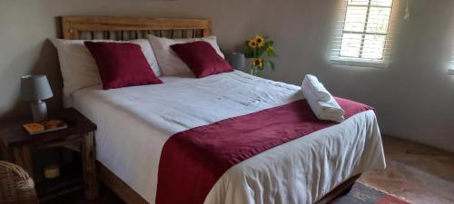 RankuKolobeng Valley的一间卧室配有一张带红色和白色床单的大床