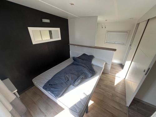 卡代纳Mobil Home confort 6p的一间卧室配有一张带蓝色毯子的床