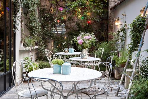 巴黎亨丽埃特酒店的两把桌子和椅子,位于种满鲜花的庭院
