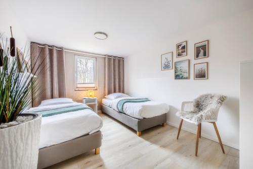 约阿希姆斯塔尔geräumiges familienfreundliches Ferienhaus 70 QM I Strandnah I Terrasse I 2 Schlafzimmer I Nähe Werbellinsee的一间卧室配有两张床和椅子