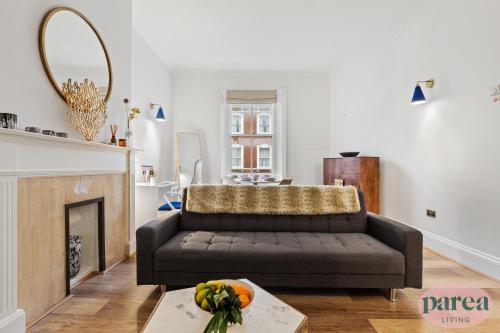 伦敦Parea Living - South Kensington, Elegant 1-Bedroom Flat, WFH Desk的带沙发和壁炉的客厅