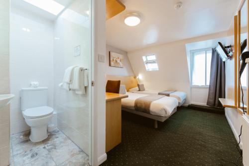 伦敦Star Hotel的浴室设有床、卫生间和水槽。