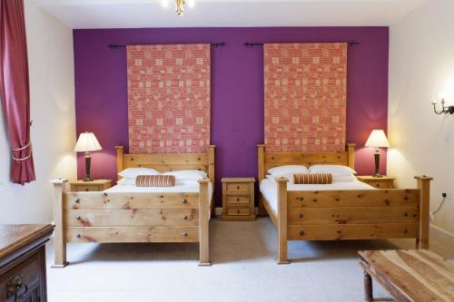 斯特灵Broomhall Castle Hotel的紫色墙壁客房的两张床