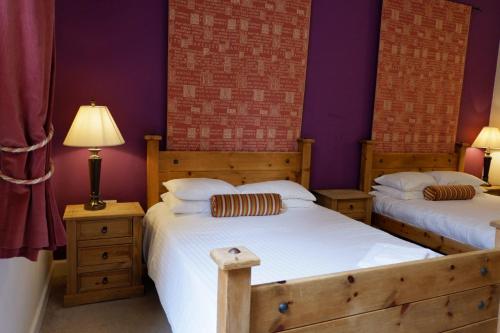 斯特灵Broomhall Castle Hotel的紫色墙壁客房的两张床