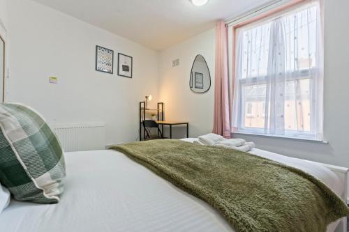 诺丁汉STAYZED N - NG7 Cosy Home, Free WiFi, Parking, Smart TV, Next To Nottingham City Centre, Ideal for Long Stays, Lots of Amenities的一间卧室配有一张带绿毯的床