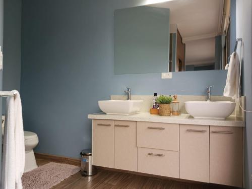 拉塔昆加BellaVista Casa de Montaña的浴室设有两个水槽和蓝色的墙壁。