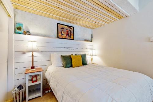 CamptonThe Mountain Sanctuary的卧室设有白色的床和木制天花板。