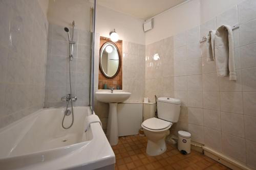 巴黎埃斯梅拉达酒店的浴室配有盥洗盆、卫生间和浴缸。