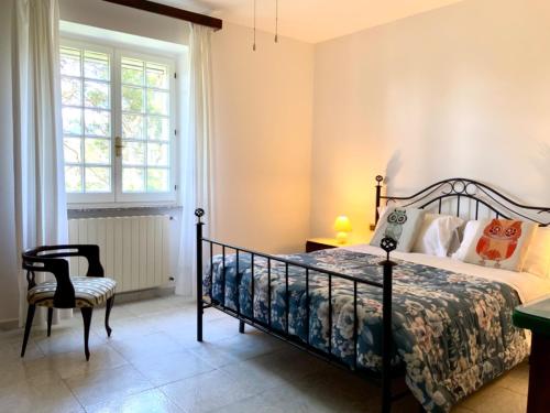 贡内萨Aragonite Azzurra Casa Vacanza的卧室配有床、椅子和窗户。