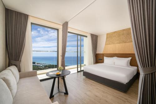 绥和市Chuỗi Căn Hộ Khách Sạn Apec Phú Yên的酒店客房设有一张床和一个大窗户