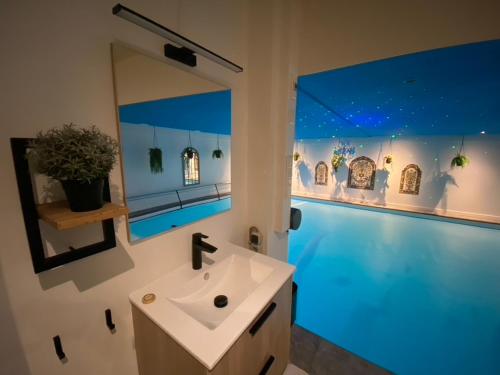 索斯特B&B Wellness Soest的一间带水槽和大镜子的浴室