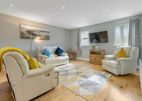 伦敦德里Benone Getaways的客厅配有两把白色椅子和地毯
