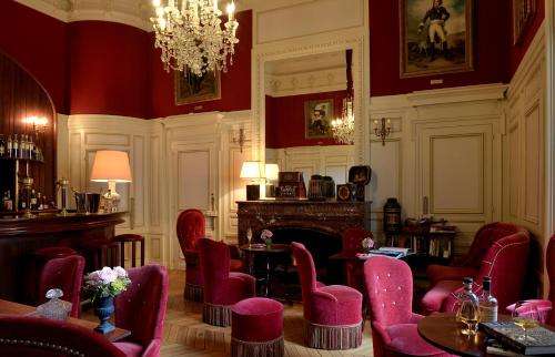 MaulévrierChateau Colbert的一间设有红色桌椅和吊灯的房间