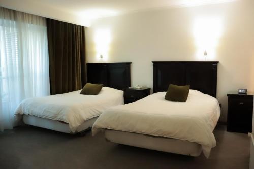 康塞普西翁Hotel Terrano Concepción的一间酒店客房,房间内设有两张床