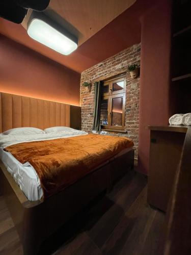 普里兹伦New Soho Hotel的一间卧室设有一张床和砖墙