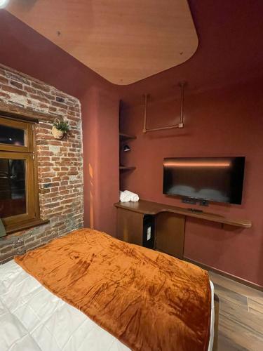 普里兹伦New Soho Hotel的一间卧室配有一张床和一台平面电视