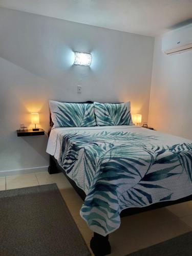 蒙特哥贝the Blue Ackee的一间卧室配有一张带蓝色和白色棉被的床