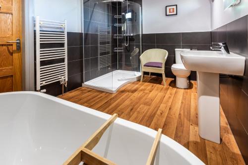 拉姆拉什Monamore Guest House的一间带水槽、浴缸和淋浴的浴室