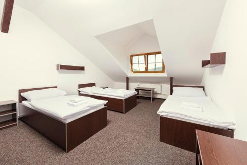克赛拉迪Ubytování Ostende - penzion的带三张床和一张桌子的房间