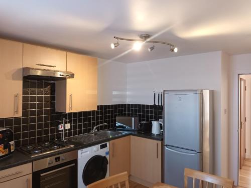 阿伯丁Spacious Elegant 2-BR Apartment in Aberdeen City Centre的厨房配有白色冰箱和水槽