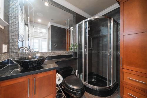 温哥华Oakridge Luxury Homestay的一间带玻璃淋浴和水槽的浴室