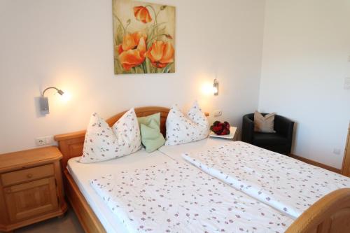 卡尔达罗Rebhof Kaltern的卧室配有一张带白色床单和枕头的大床。