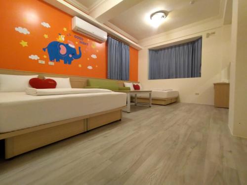 马公澎湖乐悠悠民宿的一间卧室设有一张床和橙色的墙壁