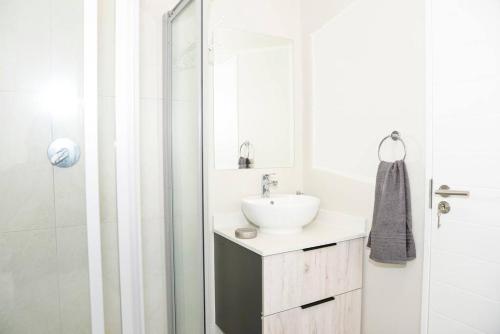 米德兰The Mansioners Apartment的白色的浴室设有水槽和淋浴。
