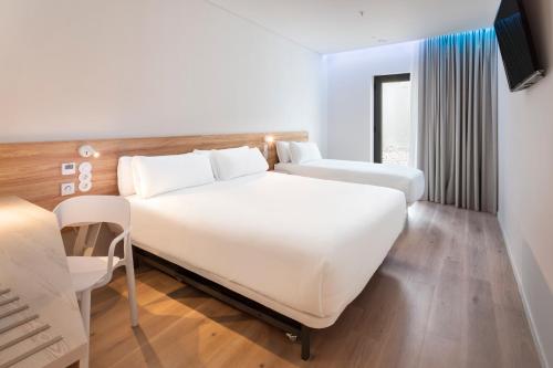奥良B&B HOTEL Olhão Algarve的酒店客房设有两张床和电视。