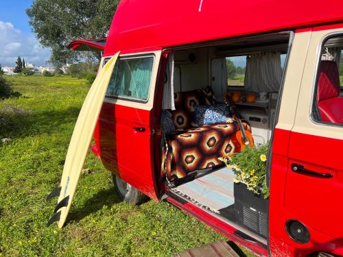 波尔蒂芒Rent a Blue Classics' s Campervan for your Road trip in Portimao -VOLKSWAGEN T3的一辆红色的货车,门开,有一堆装置