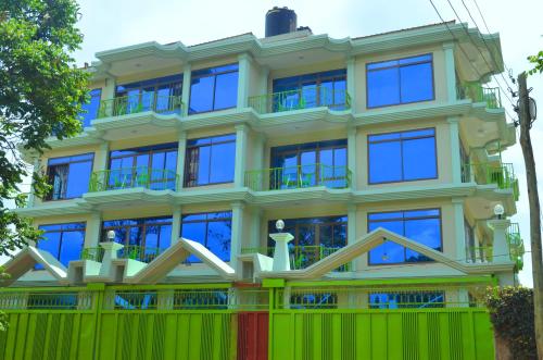 阿鲁沙Luxury Budget Hotels的前面有绿色围栏的建筑