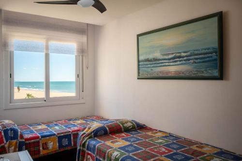 托里代巴拉AT020 Torremar I的一间卧室设有一张床和一个海滩窗口
