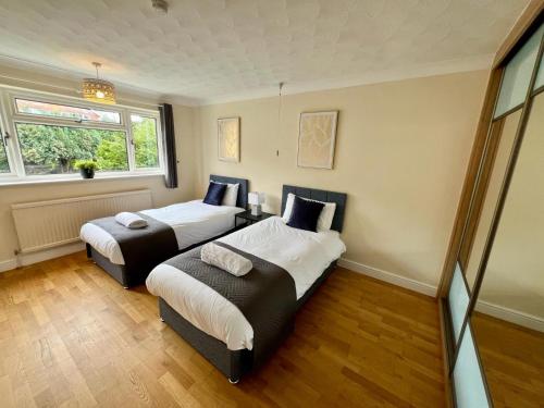 诺里奇Clovelly House的一间卧室设有两张床和窗户。
