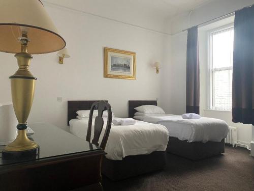 坎贝尔城阿盖尔阿姆酒店的客房设有两张床和一张带台灯的桌子。