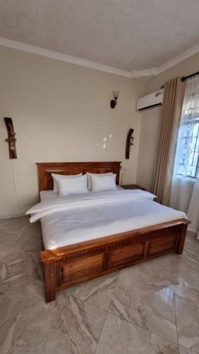 MsarangaMaisha Apartment的一间卧室配有一张木架大床